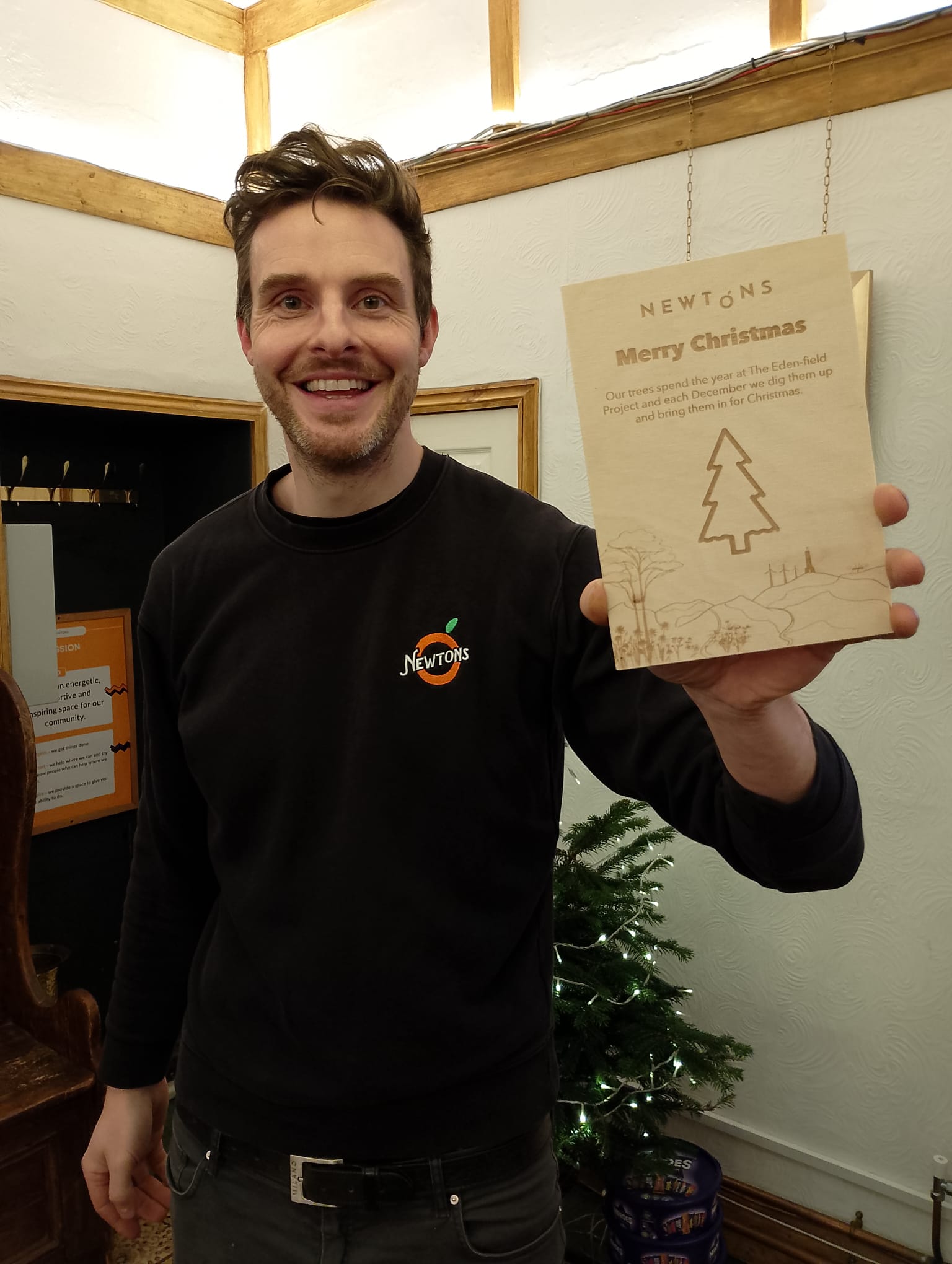 Matthew at Newtons showing wooden sign